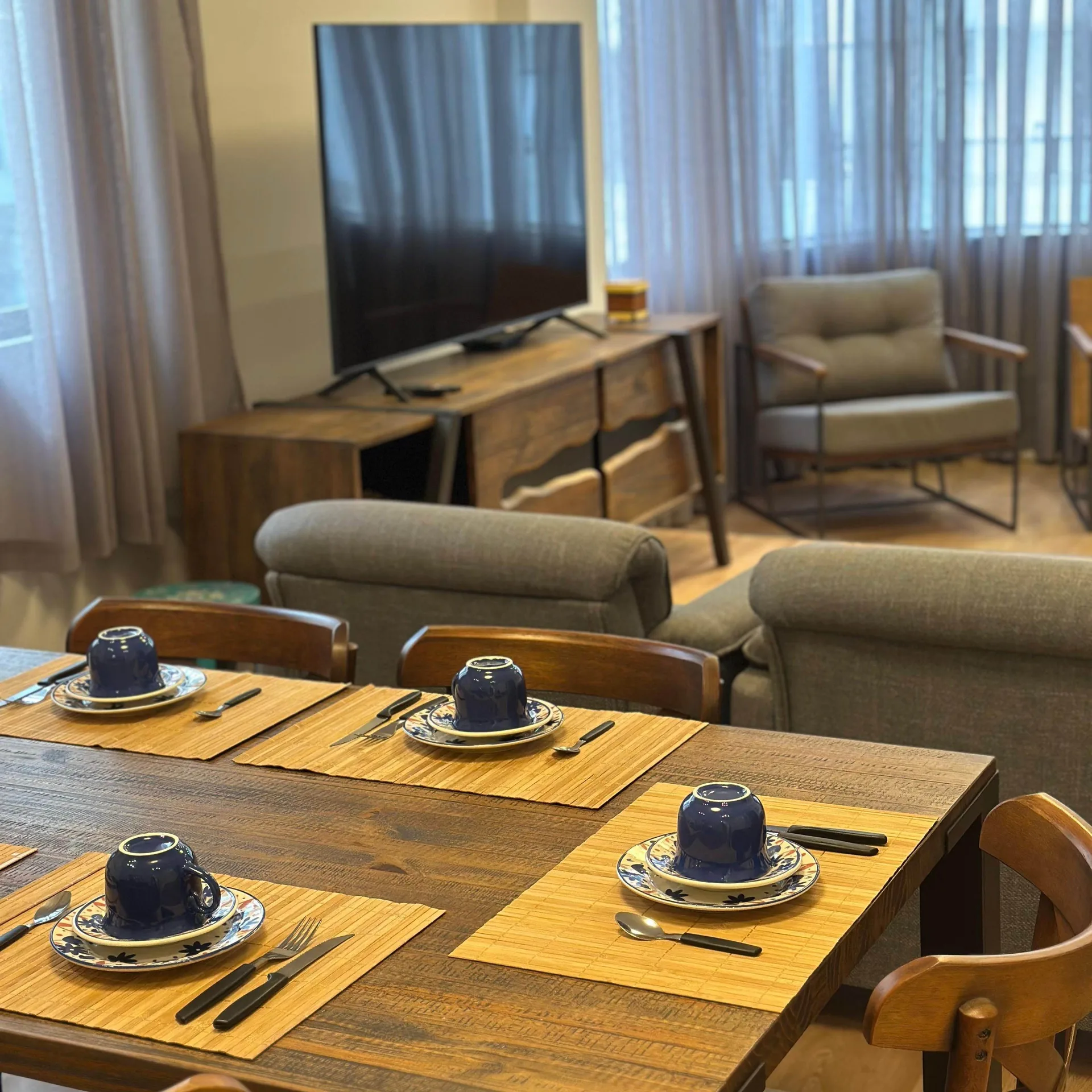 Sala ampla e iluminada do apartamento em Balneário Camboriú com piso de madeira