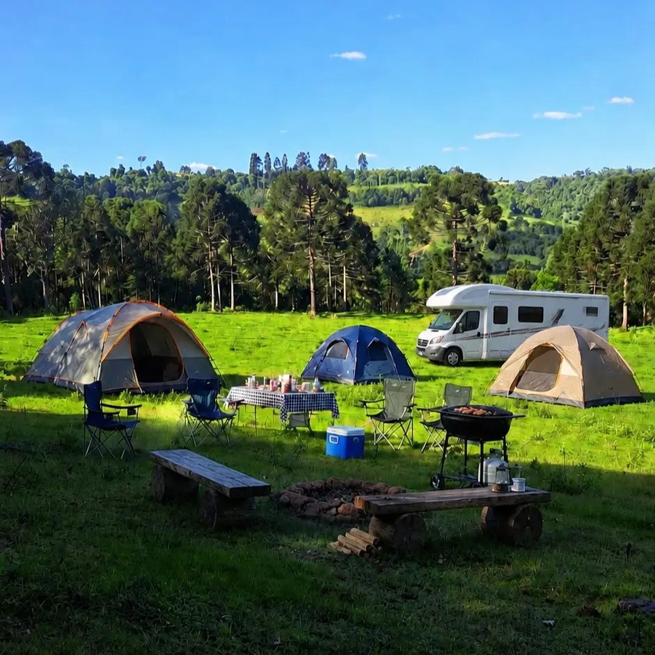 Área de camping com barracas e motorhome no campo