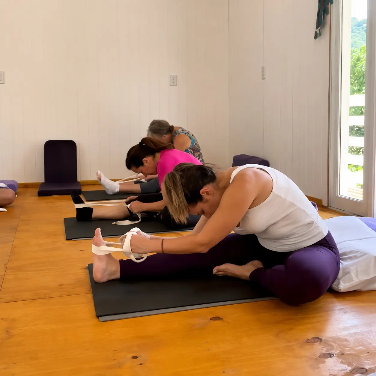 Alongamento assistido durante a prática na sala de yoga